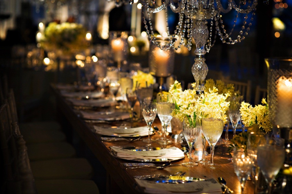 Long wooden dinner tables crystal chandeliers yellow flowers philadelphia weddings