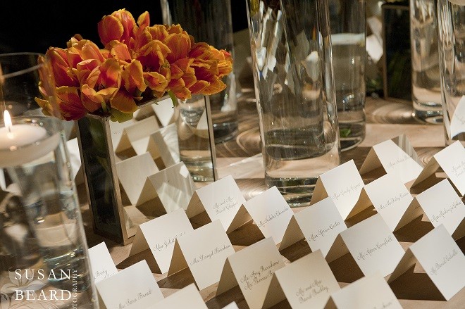 Elegant hand calligrahed escort cards line up on the place card table. Evantine Design.