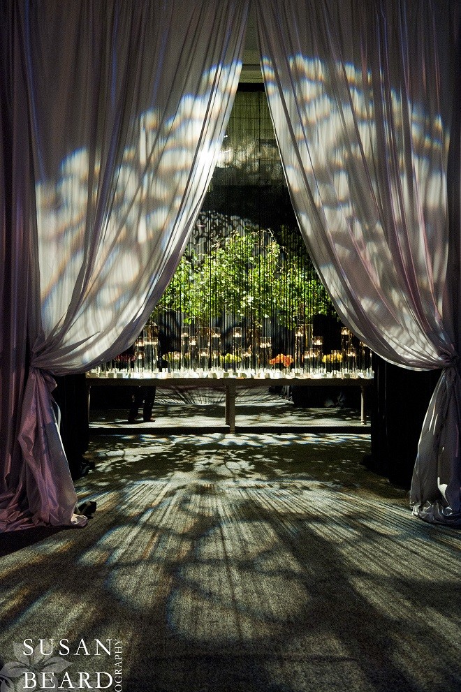 party entrance black fringe drape long placecard table with branches and flowers evantine design